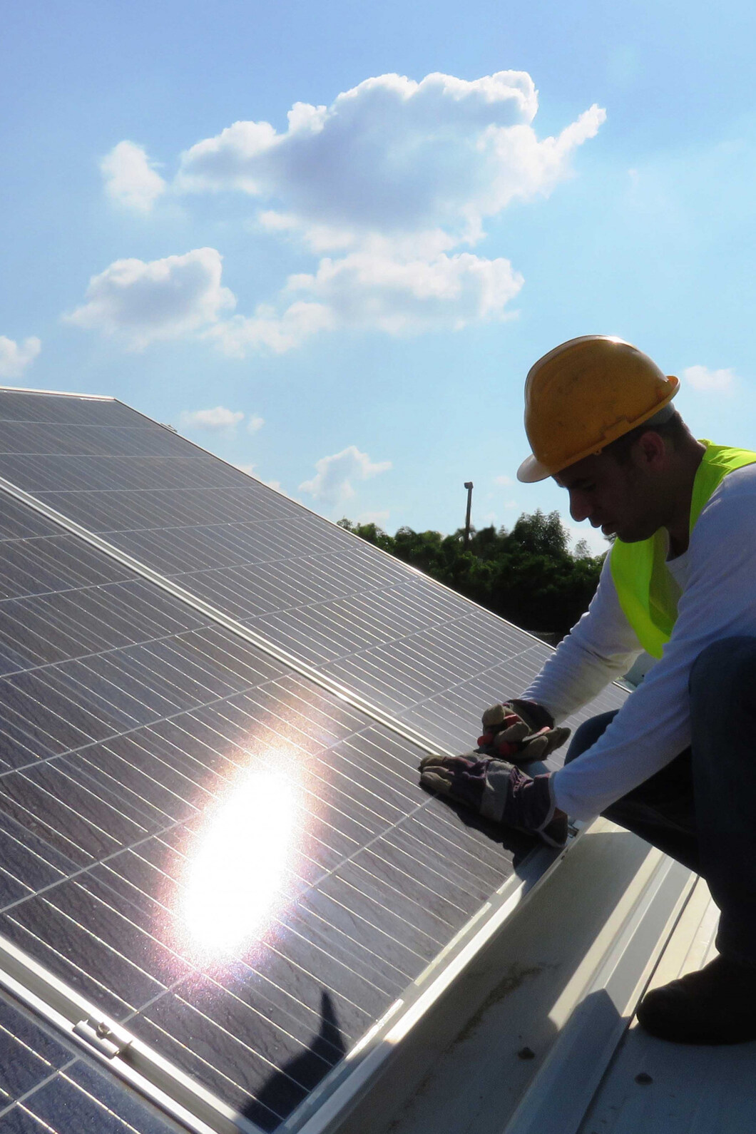 Man werkt op dak aan zonnepanelen.