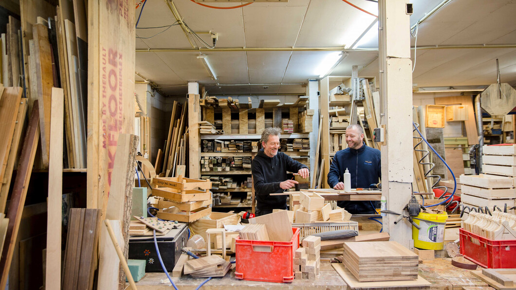 Twee mannen werken samen in een hout atelier.