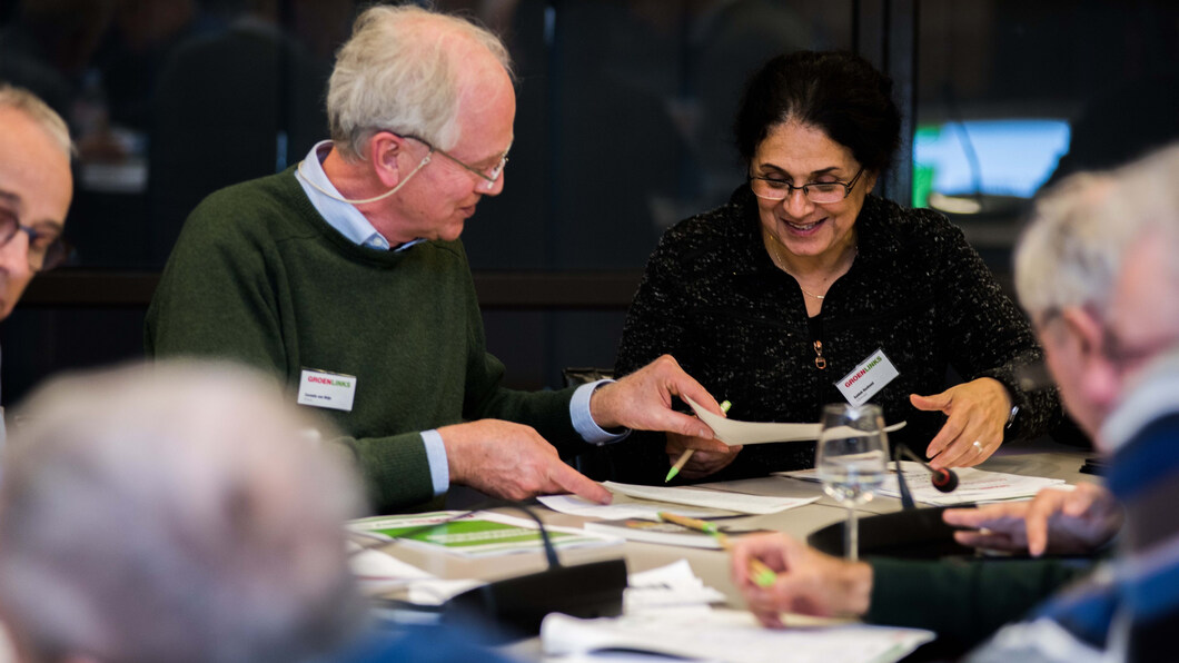 Twee GroenLinks medewerkers bekijken samen een papier